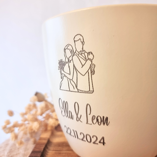 Beiger Blumentopf mit Gravur eines Brautpaares, Namen "Ella & Leon" und Hochzeitsdatum "22.11.2024". Personalisiertes Hoch...